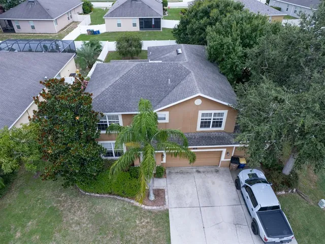 an aerial view of a house with yard and trees