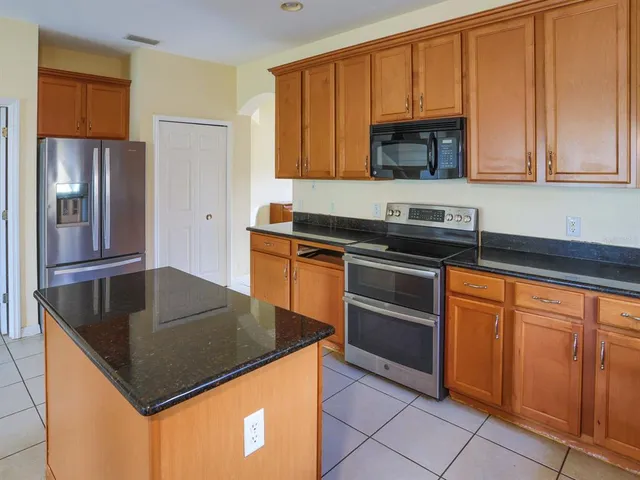 a kitchen with stainless steel appliances granite countertop a sink stove and microwave