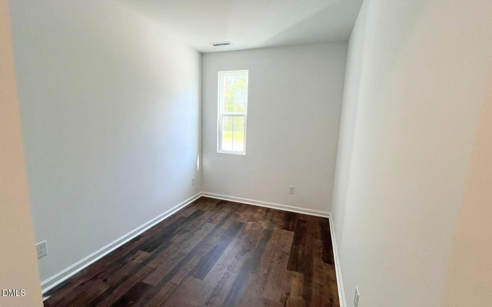 2430 Whitewing Lane Wendell, NC 27591 - Photo 8 of 31 a view of an empty room with wooden floor and a window