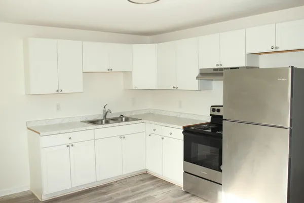 a kitchen with appliances a sink and cabinets