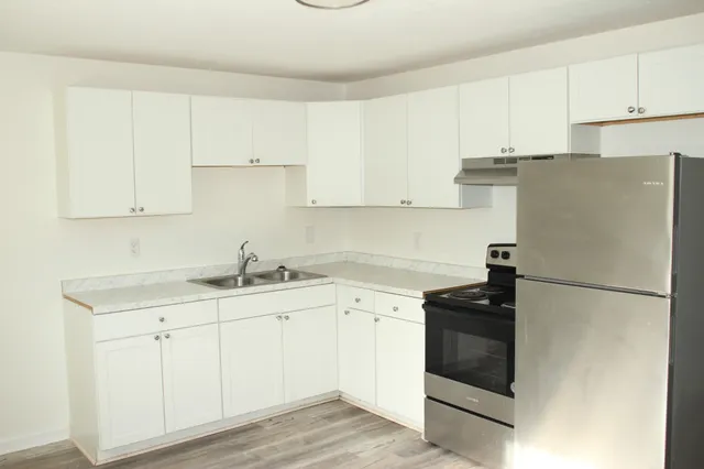 a kitchen with appliances a sink and cabinets