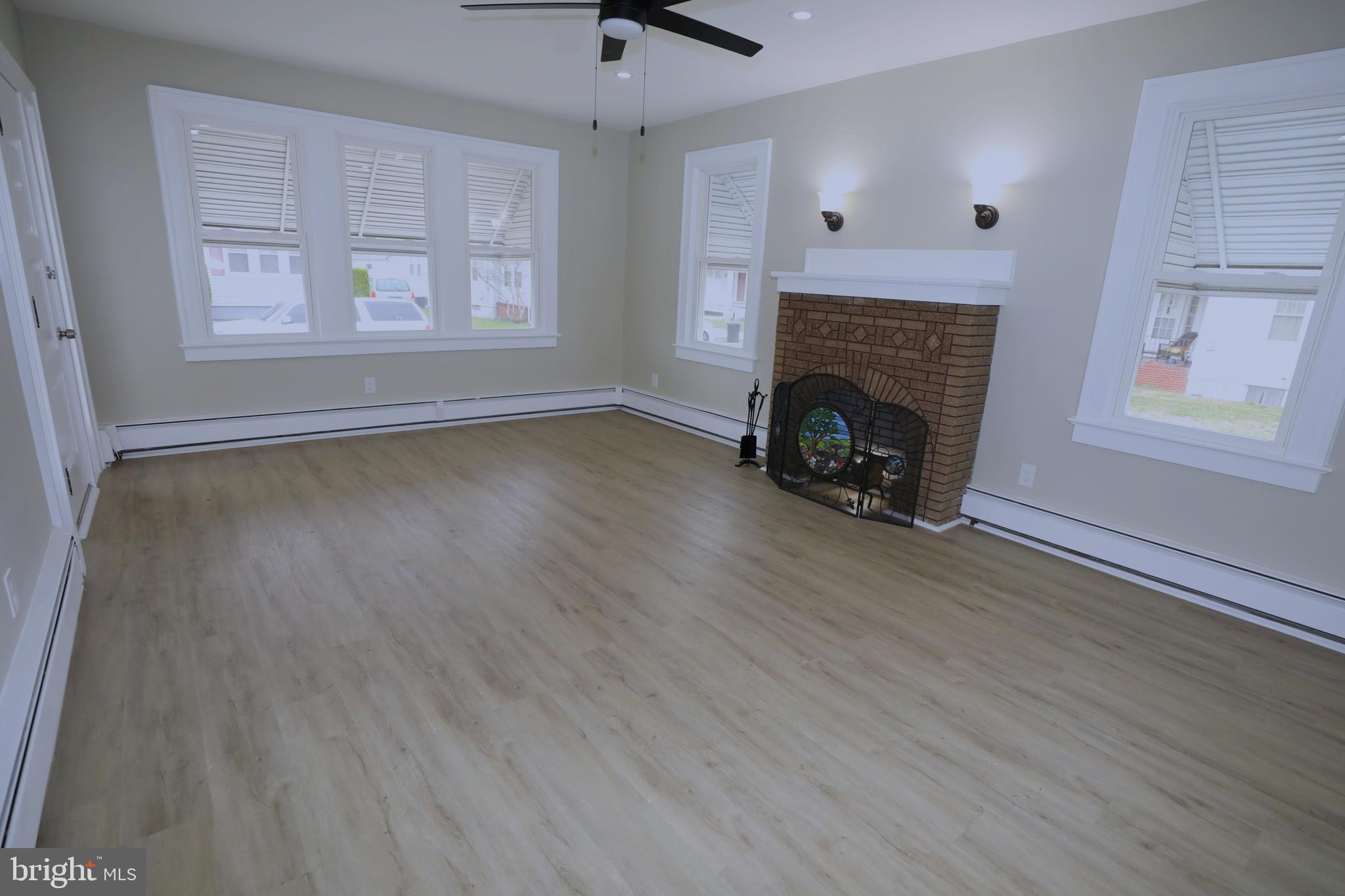 36 Emanuel Street Hamilton, NJ 08610 - Photo 3 of 26 a view of an empty room with wooden floor fireplace and a window
