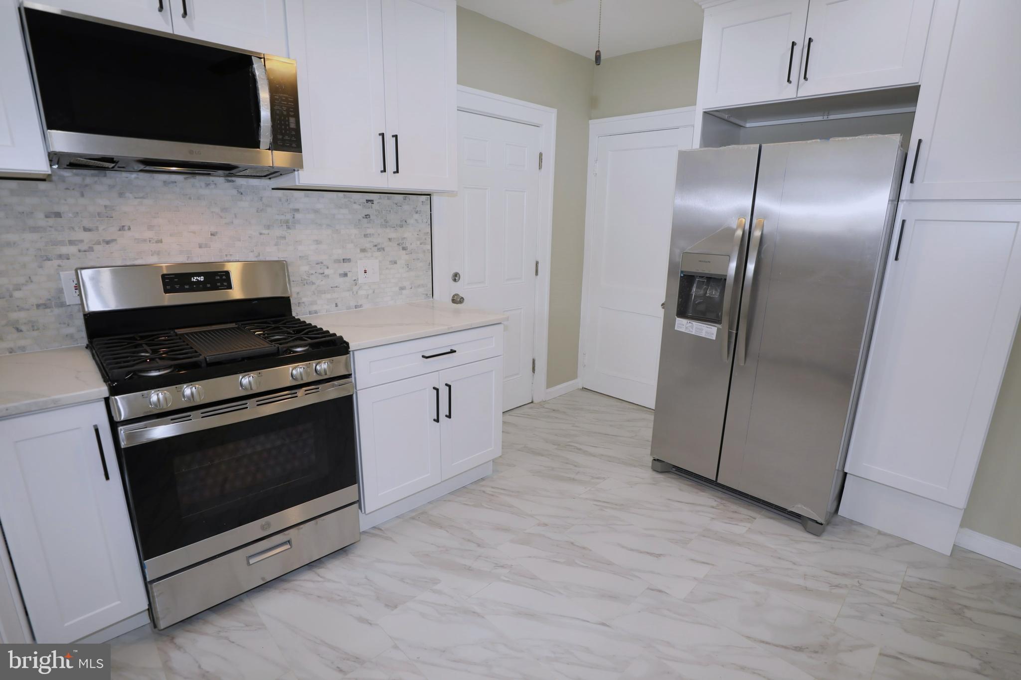 36 Emanuel Street Hamilton, NJ 08610 - Photo 9 of 26 a kitchen with granite countertop a stove and a microwave