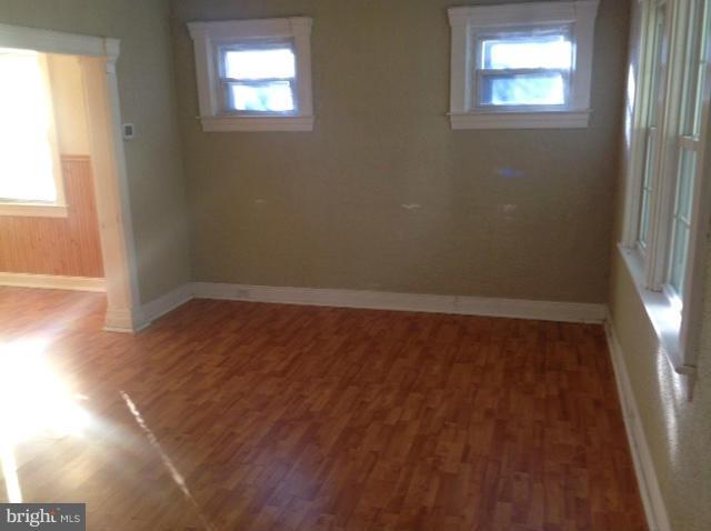 6823 Dunhill Road Baltimore, MD 21222 - Photo 3 of 13 an empty room with wooden floor and windows