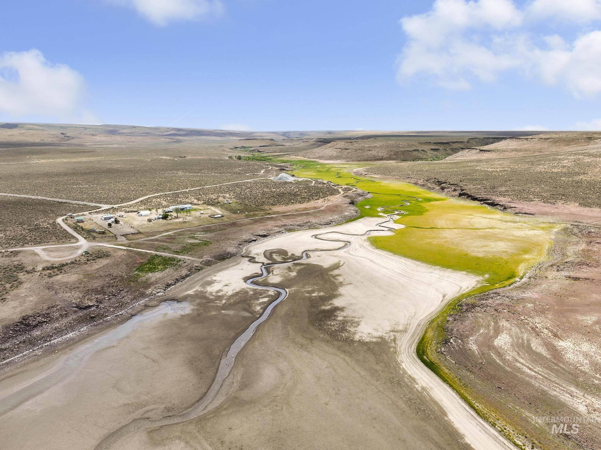 758 Cedar Crk Road Rogerson, ID 83302 - Photo 47 of 50 Expansive desert landscape featuring a winding riverbed, vibrant green vegetation, and distant structures