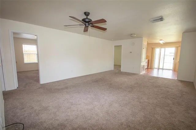 a view of a livingroom with a ceiling fan and window
