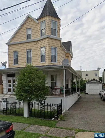 a view of a white house with large windows and a table and chairs