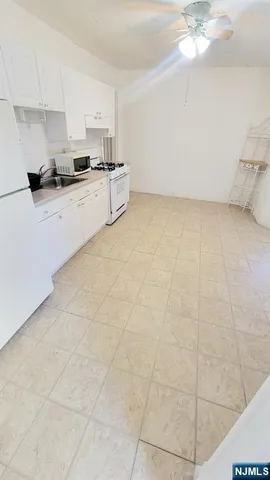 a kitchen with granite countertop a sink a stove a microwave and cabinets