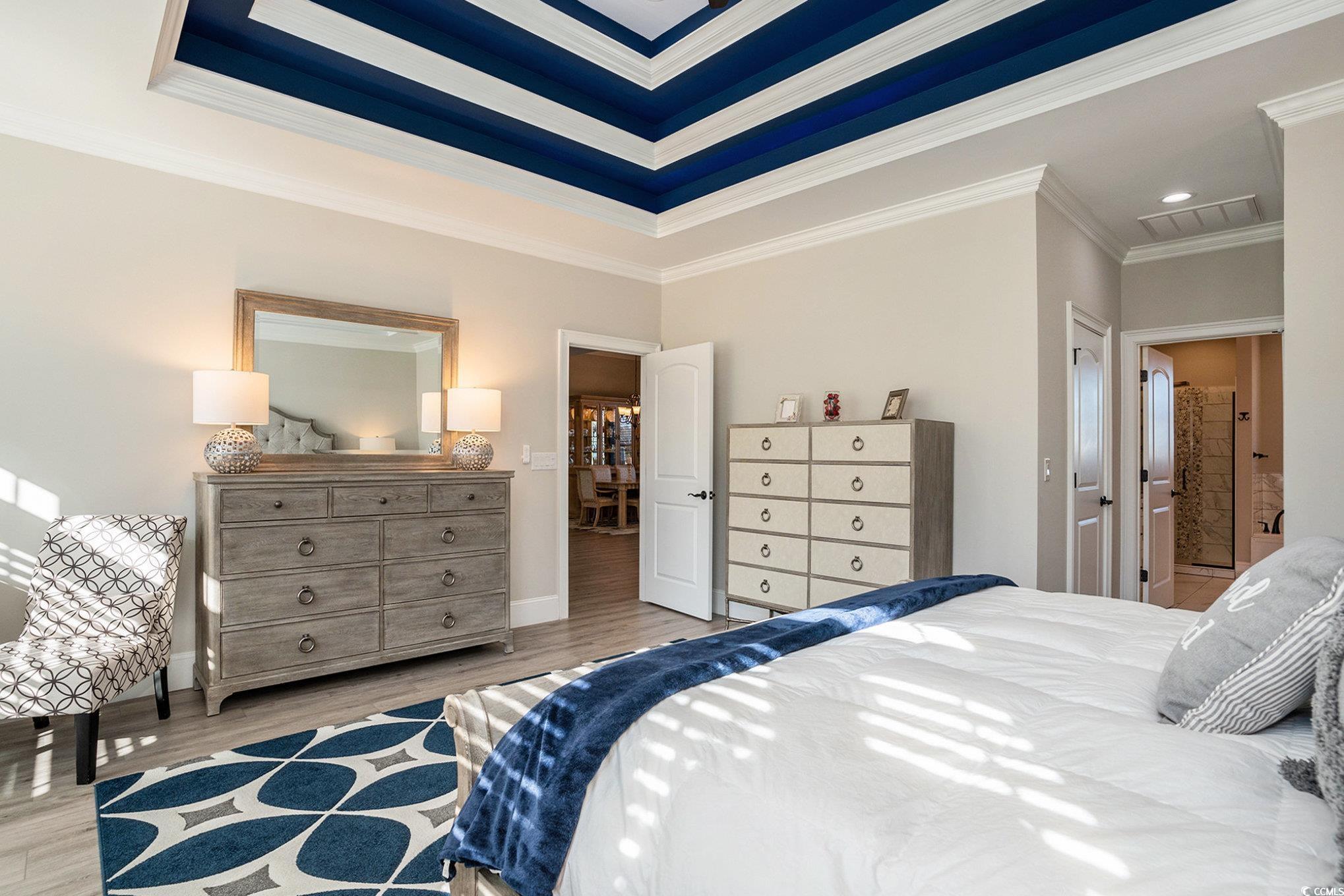 1009 Dowitcher Drive Conway, SC 29526 - Photo 16 of 40 Bedroom featuring crown molding, connected bathroom, wood finished floors, recessed lighting, and a tray ceiling