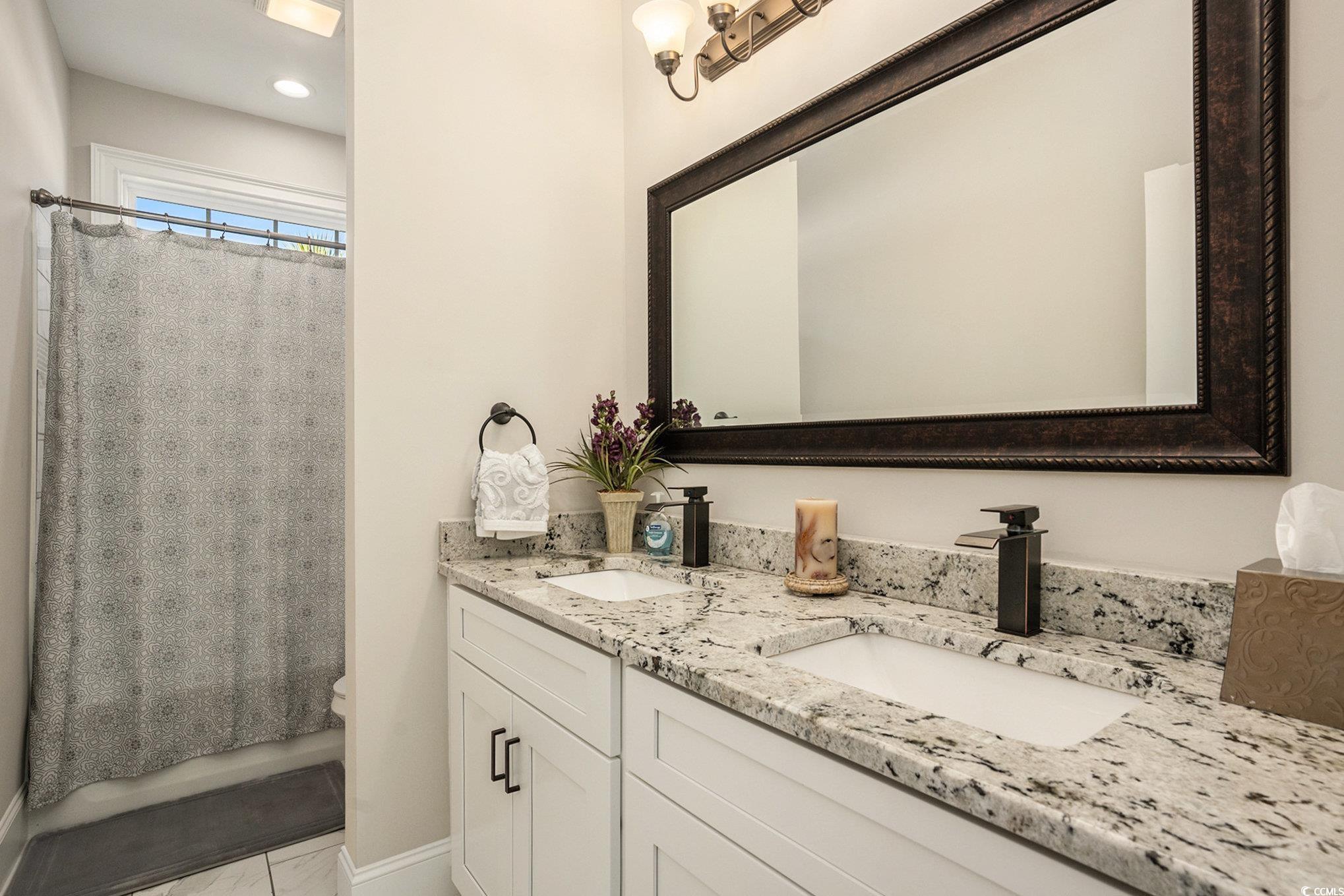 1009 Dowitcher Drive Conway, SC 29526 - Photo 21 of 40 Bathroom featuring double vanity and shower / bathtub combination with curtain