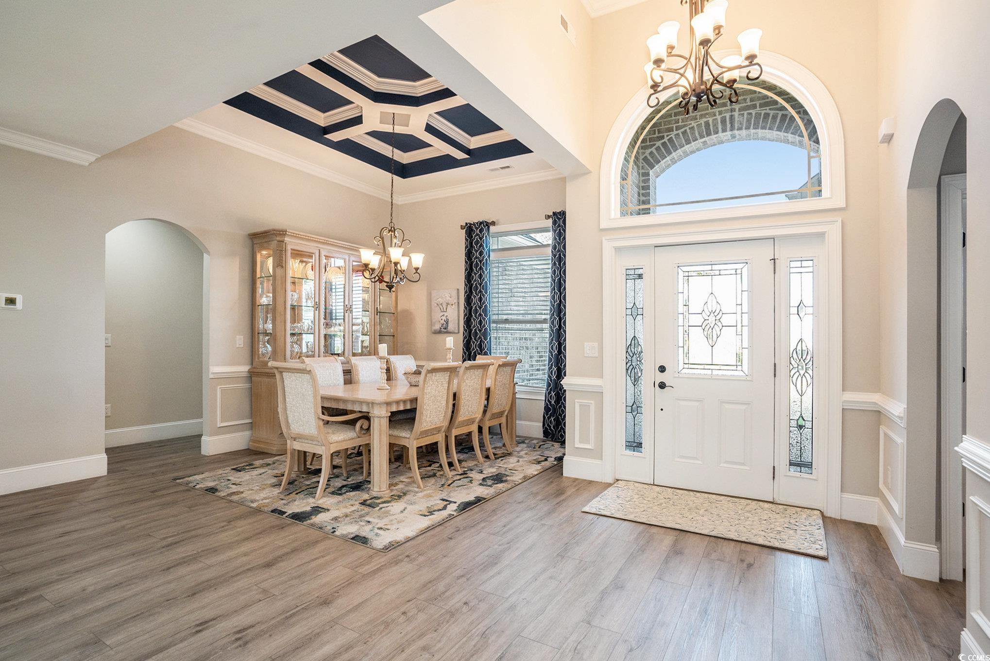 1009 Dowitcher Drive Conway, SC 29526 - Photo 4 of 40 Foyer entrance with arched walkways, a chandelier, plenty of natural light, a wainscoted wall, and ornamental molding