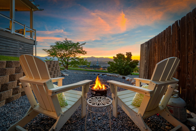 14883 Tooele Lane Draper, UT 84020 - Photo 49 of 49 Outdoor entertainment space featuring a gravel patio, built-in retaining wall, and a wood privacy fence