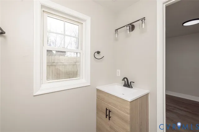 a bathroom with a sink a mirror and a window