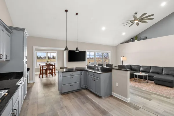 a living room with furniture flat screen tv and kitchen view