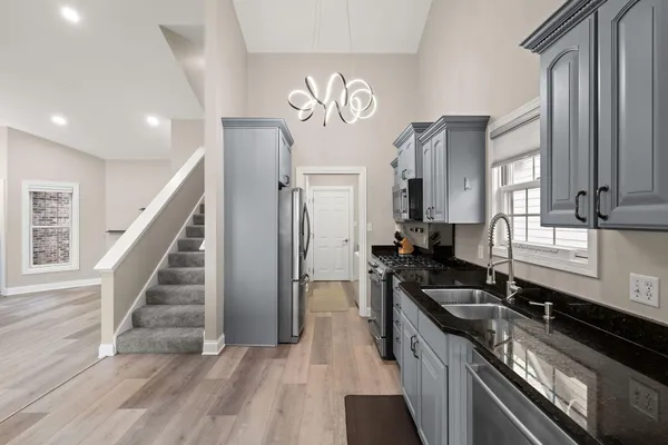 a kitchen with granite countertop a stove and a sink