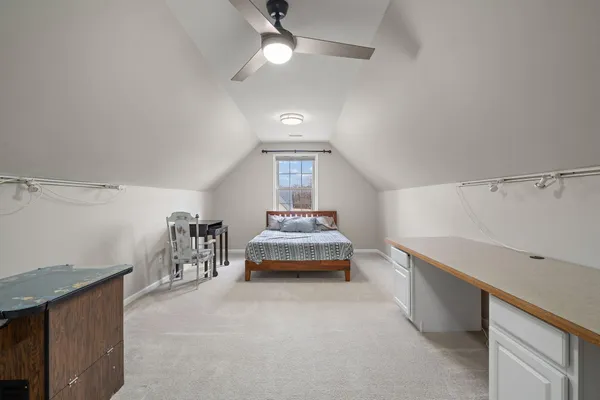 a spacious bedroom with a bed and a chandelier