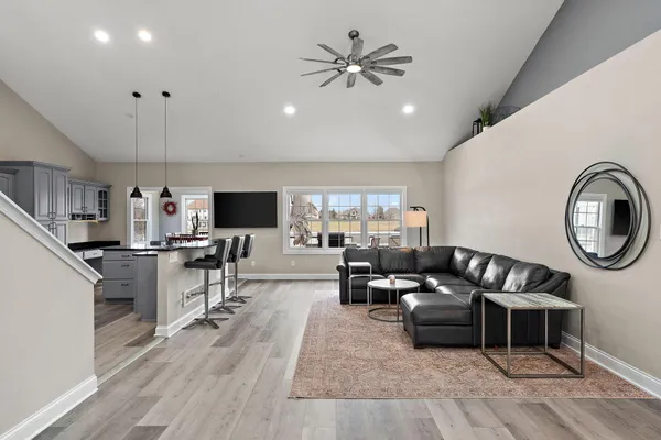 a living room with furniture a flat screen tv and kitchen view