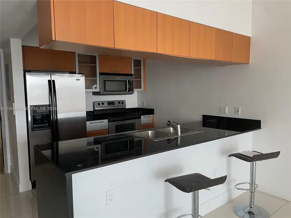 a kitchen with stainless steel appliances a refrigerator and a stove top oven