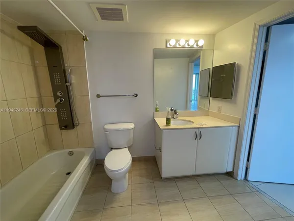 a bathroom with a sink a toilet a mirror a vanity and bathtub