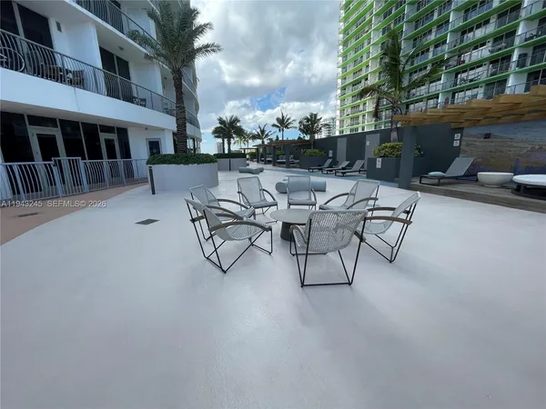 a view of a patio with a table and chairs and potted plants