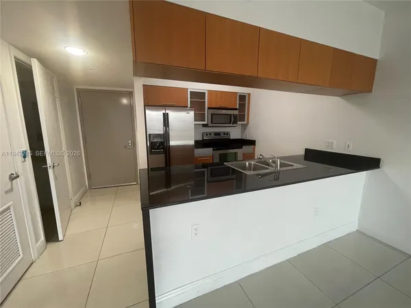 a kitchen with granite countertop a refrigerator and a sink