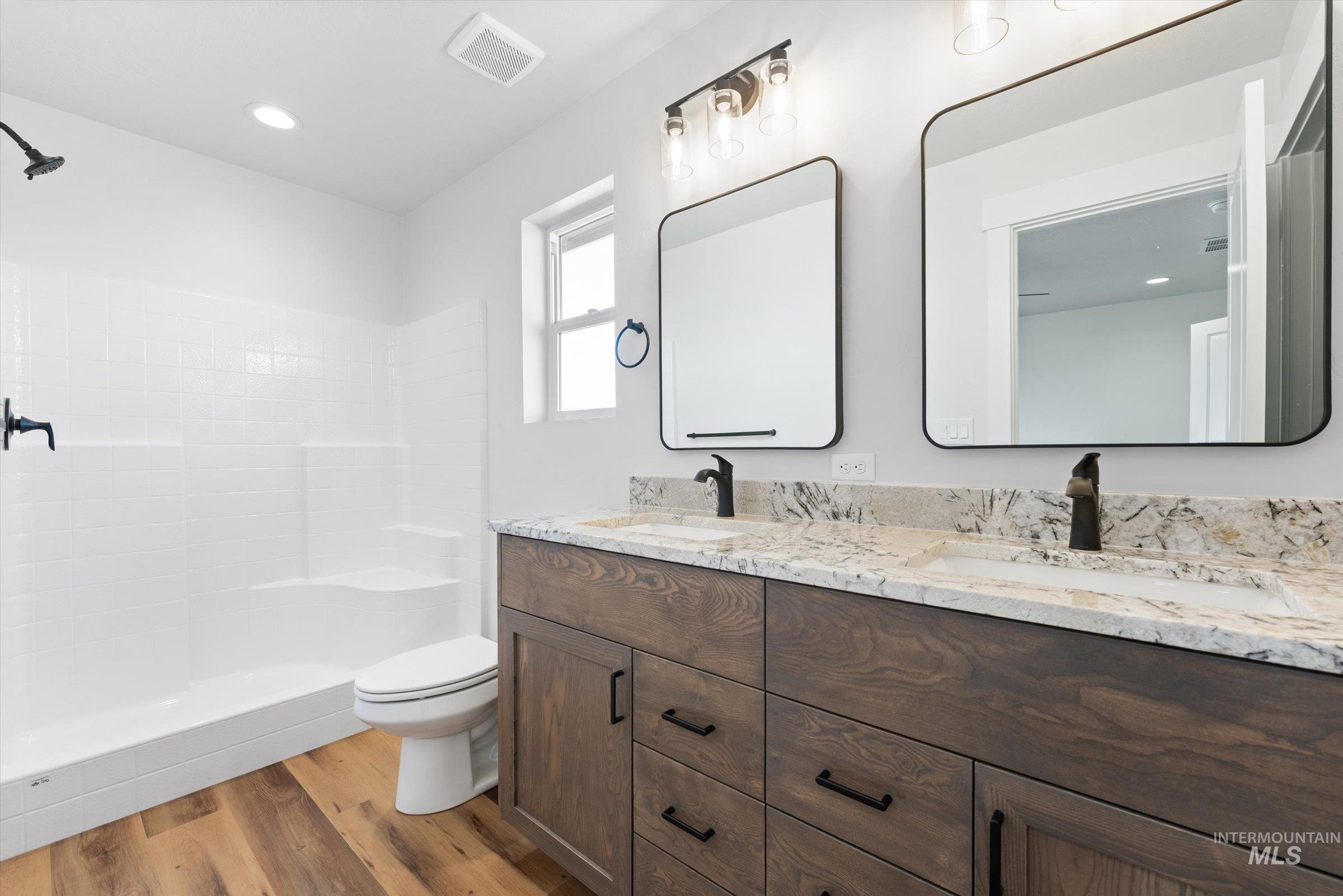 1142 Velvet Loop Wilder, ID 83676 - Photo 12 of 27 Full bathroom featuring double vanity, light wood-style floors, a tile shower, and recessed lighting