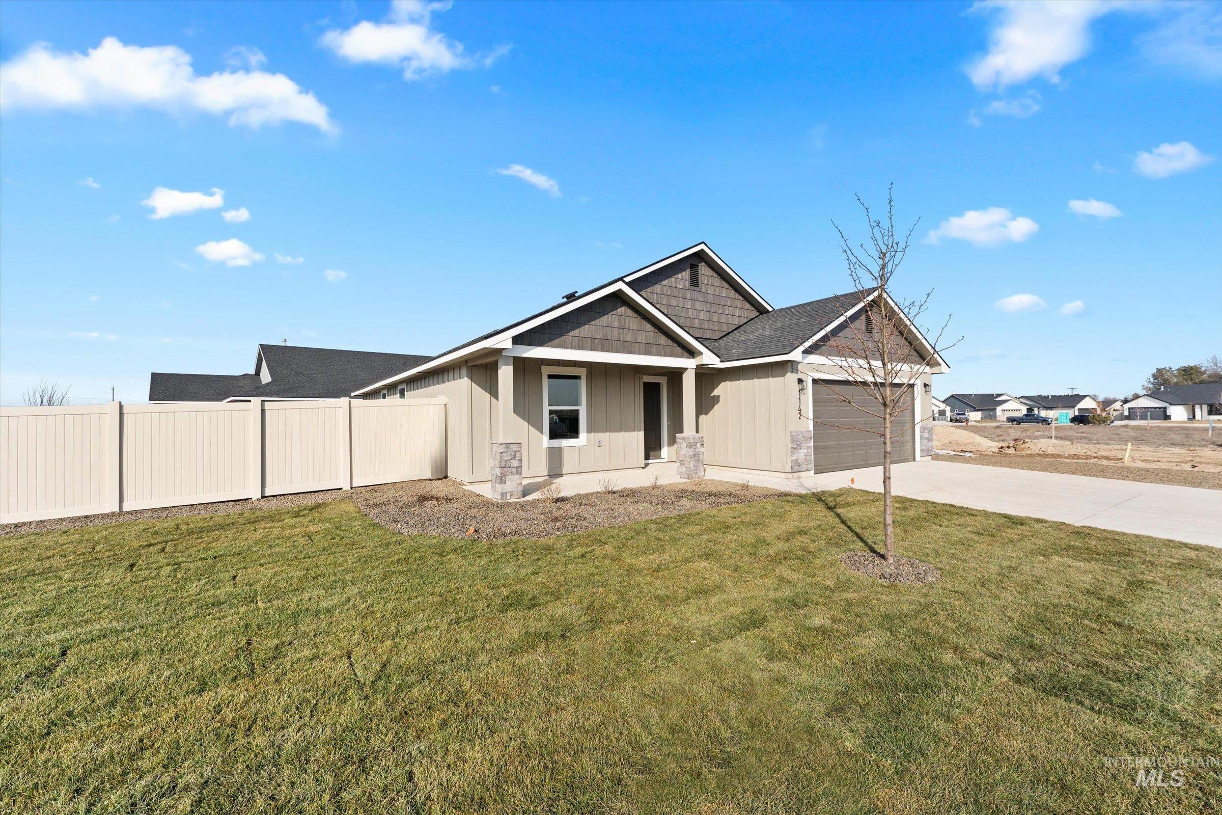1142 Velvet Loop Wilder, ID 83676 - Photo 2 of 27 View of front of home featuring board and batten siding, a garage, concrete driveway, and covered porch