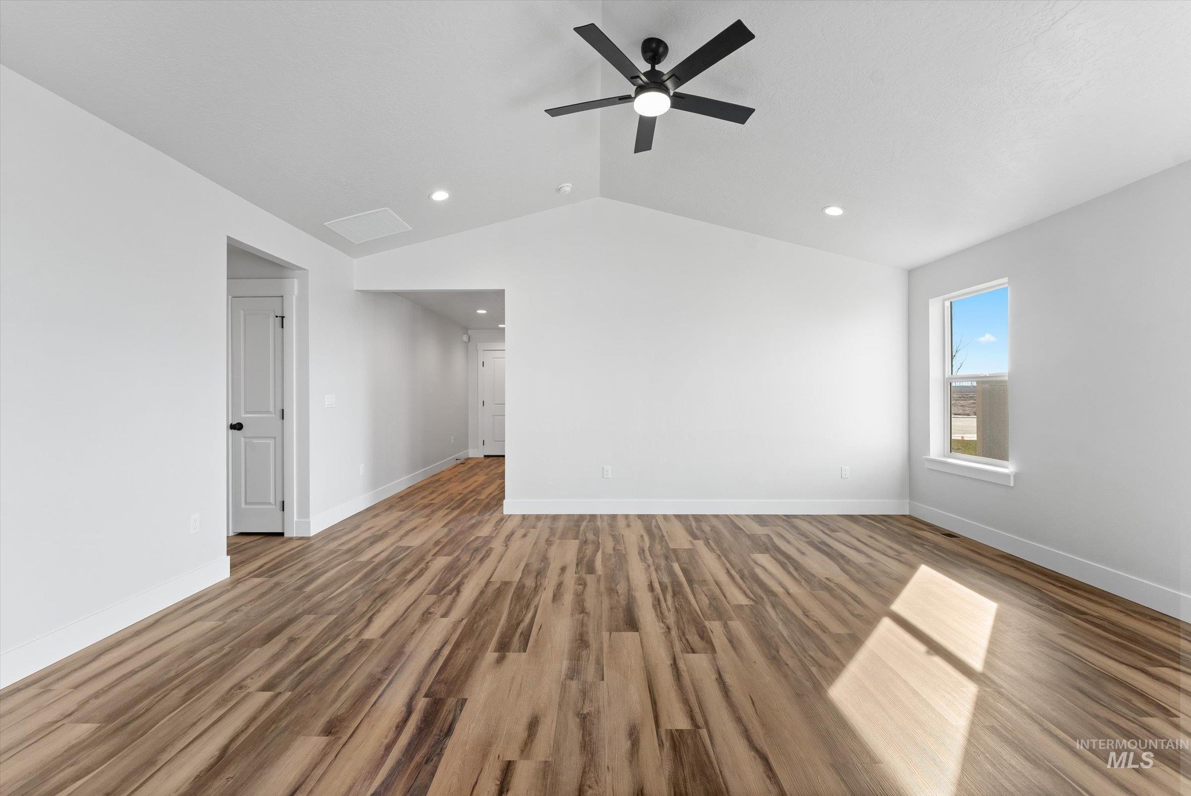 1142 Velvet Loop Wilder, ID 83676 - Photo 5 of 27 Spare room with wood finished floors, a ceiling fan, vaulted ceiling, and recessed lighting