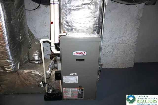 a view of water heater room with a refrigerator