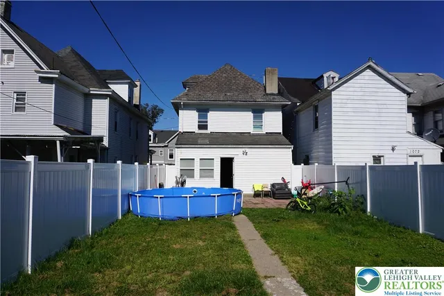 a view of a house with a yard and potted plants