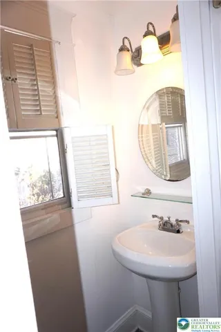 a bathroom with a sink a mirror and a window