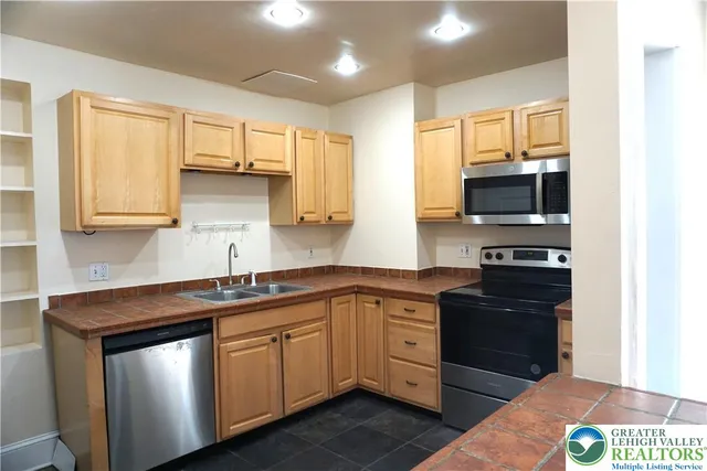 a kitchen with stainless steel appliances granite countertop a sink and cabinets