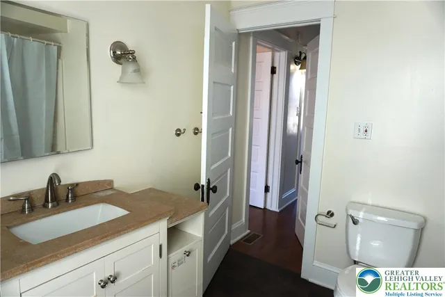 a en suite bathroom with a granite countertop sink and a mirror