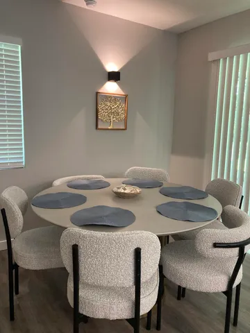 a living room with stainless steel appliances granite countertop furniture wooden floor a fireplace and a kitchen view