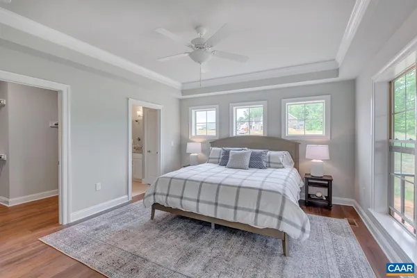 a bedroom with a bed and a window with wooden floor