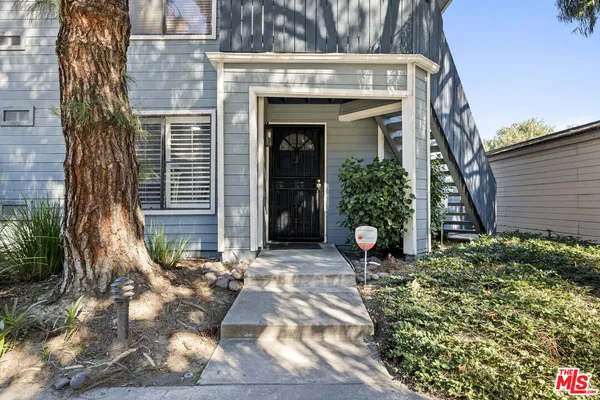 a view of a house with potted plants
