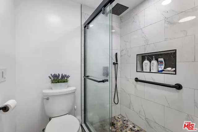 a bathroom with a toilet and a shower