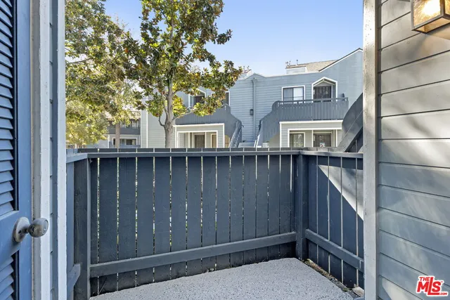 a view of a house with a small yard and wooden fence