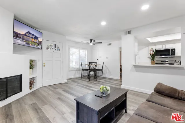 a living room with furniture and a kitchen area