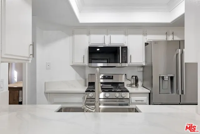 a kitchen with stainless steel appliances a refrigerator and a stove top oven