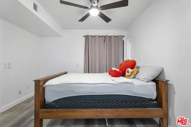 a bedroom with a bed and a chandelier fan