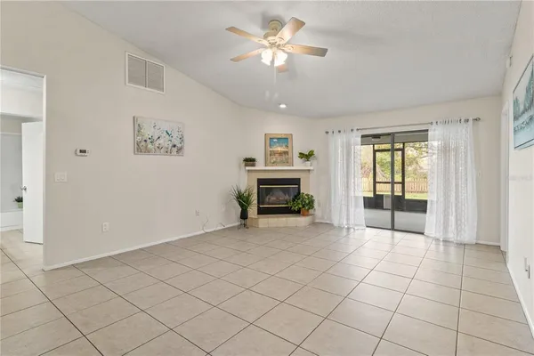 a view of a livingroom with a chandelier fan and windows