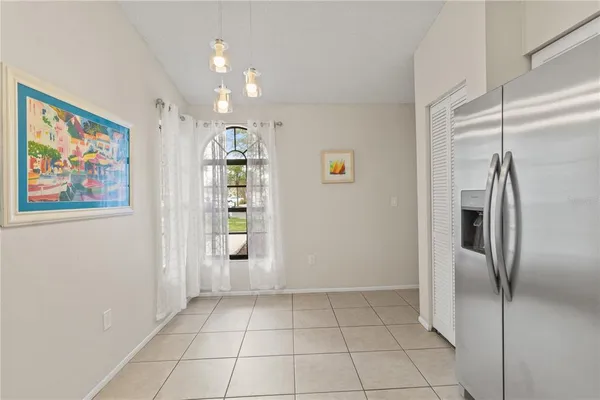 a view of a refrigerator in kitchen and an empty room