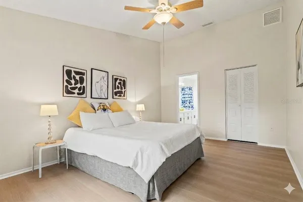 a bedroom with a large bed and a chandelier