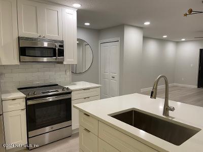 a kitchen with white cabinets a sink and stainless steel appliances