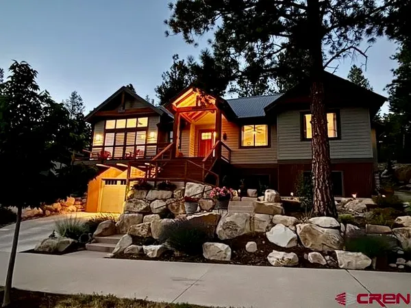 a front view of a house with a yard and trees