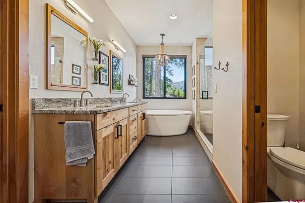 a bathroom with a granite countertop toilet sink and mirror