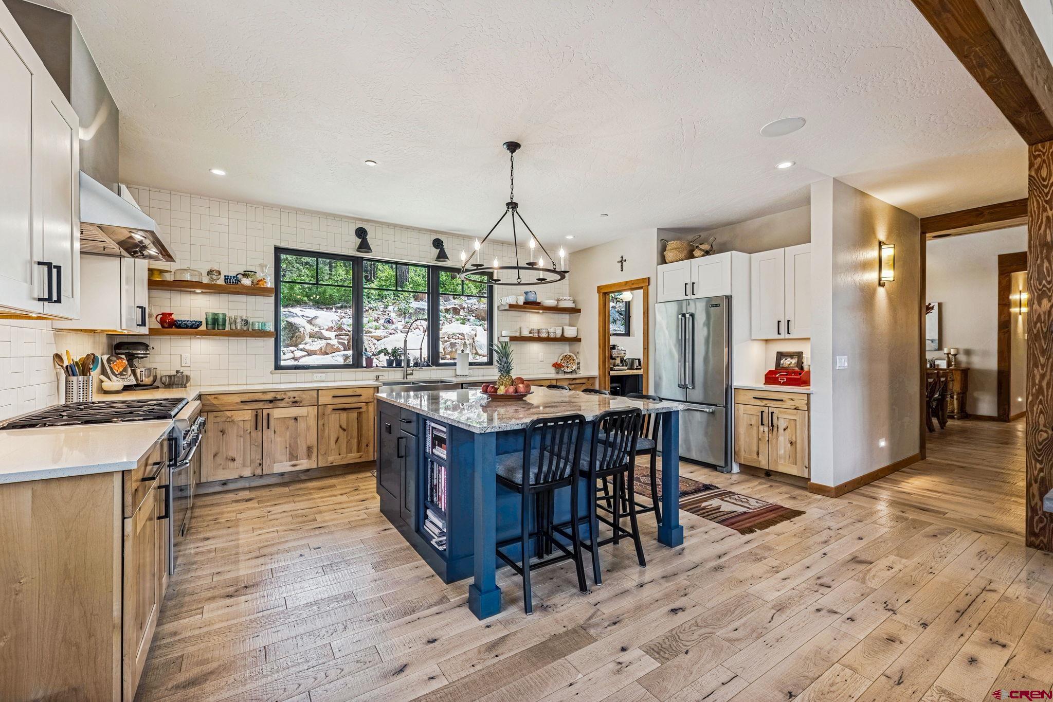 1022 Twin Buttes Avenue Durango, CO 81301 - Photo 6 of 45 a kitchen with stainless steel appliances granite countertop a table chairs and a refrigerator