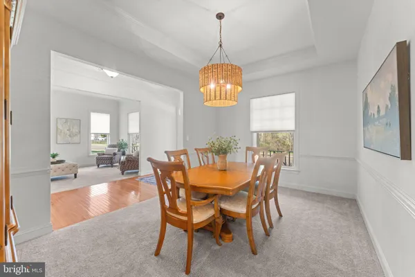 a dining room with furniture a chandelier and wooden floor