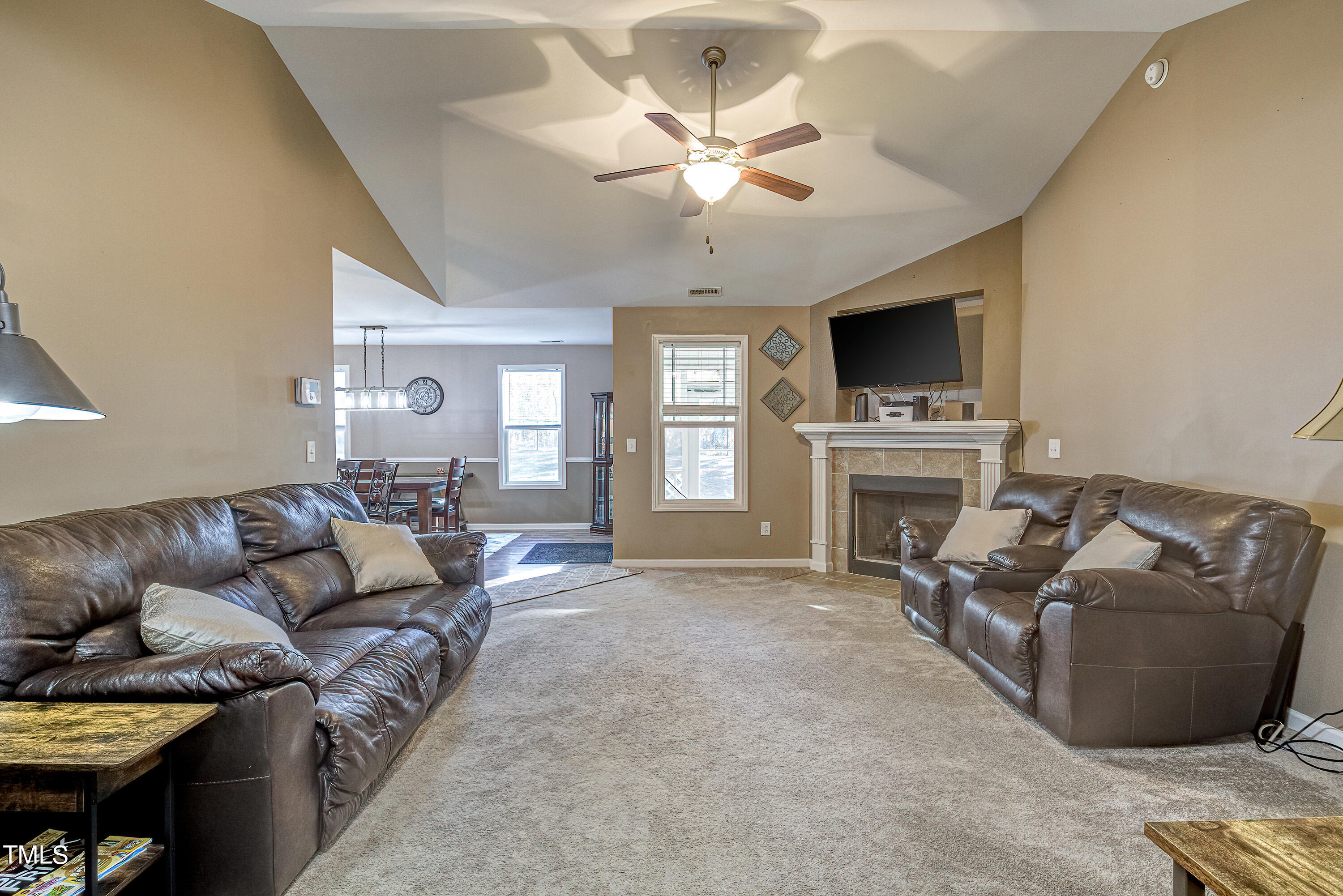 235 Highcroft Circle Benson, NC 27504 - Photo 6 of 25 a living room with furniture a flat screen tv and a fireplace